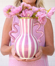 Load image into Gallery viewer, Person holding a pink and white striped vase with floral decorations.
